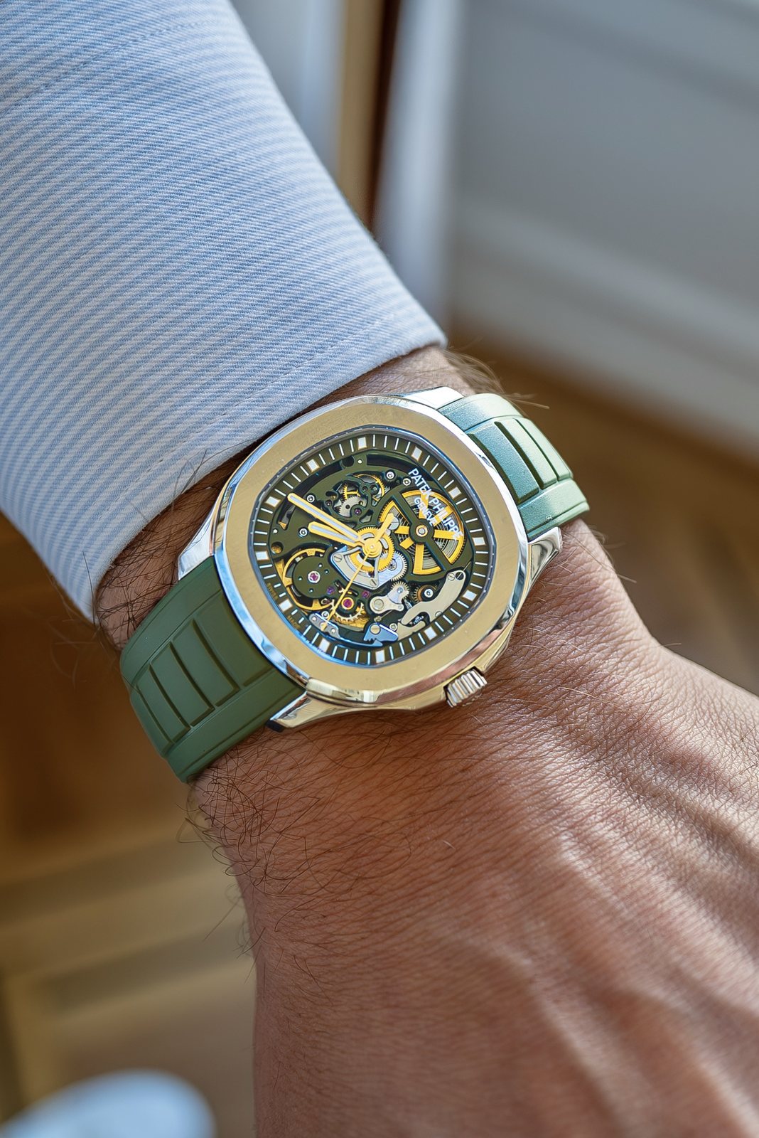 The Eternal Green Aquanaut on the wrist, with an olive-green openworked plate and its rotor, wheels, hands and polished bezel reading gold