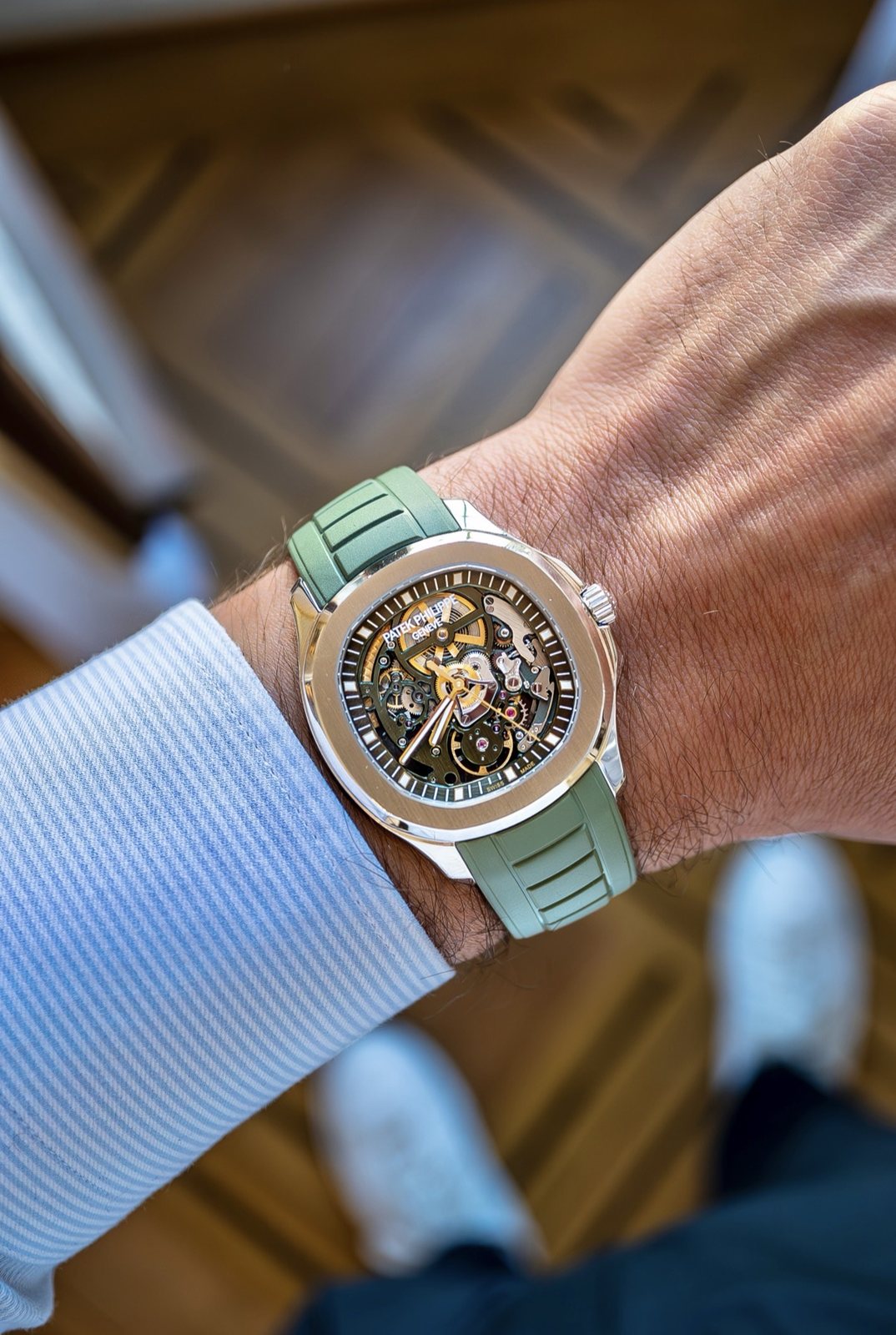 The watch on the wrist under a shirt cuff, seen from above