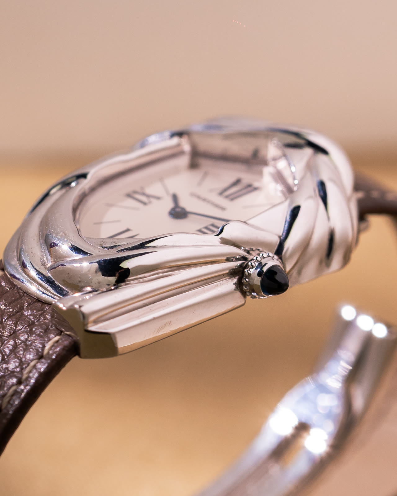 The Cheich at an angle, showing the woven white-gold case around the dial