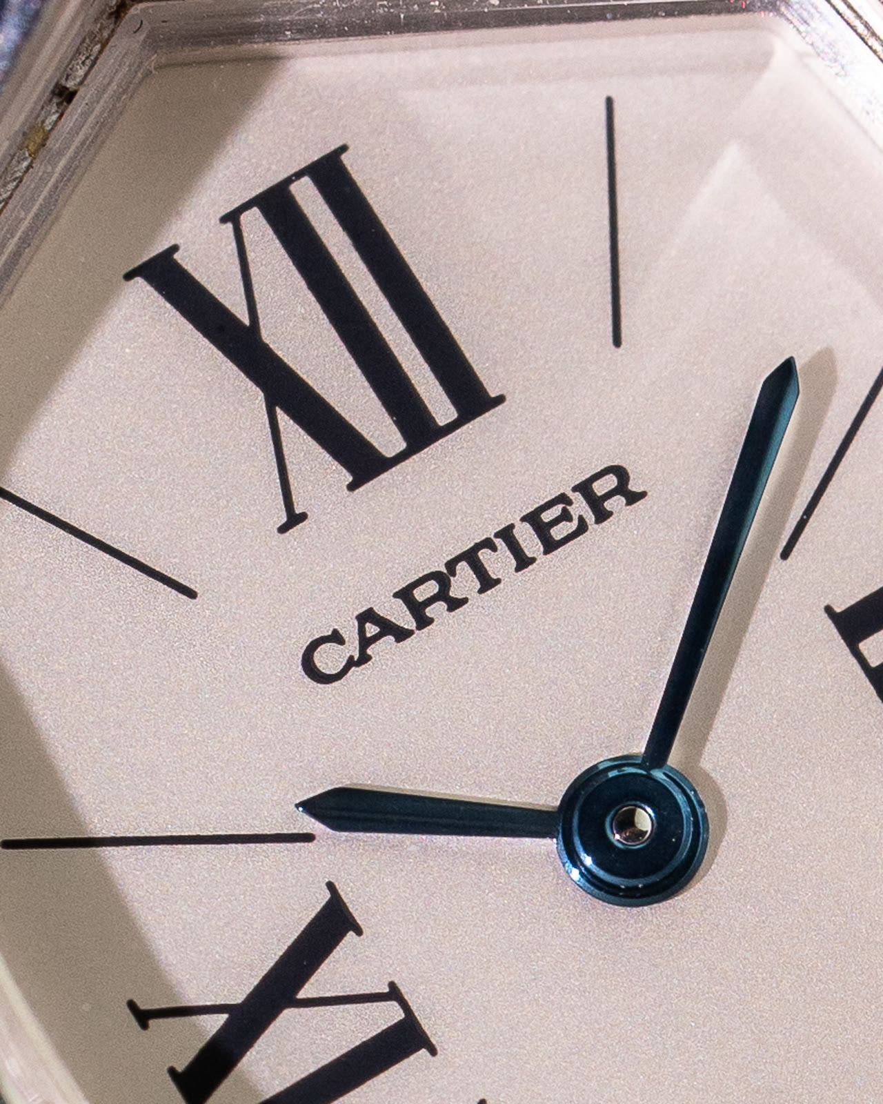 Macro of the Cheich dial showing Roman numerals, blued hands and the Cartier signature