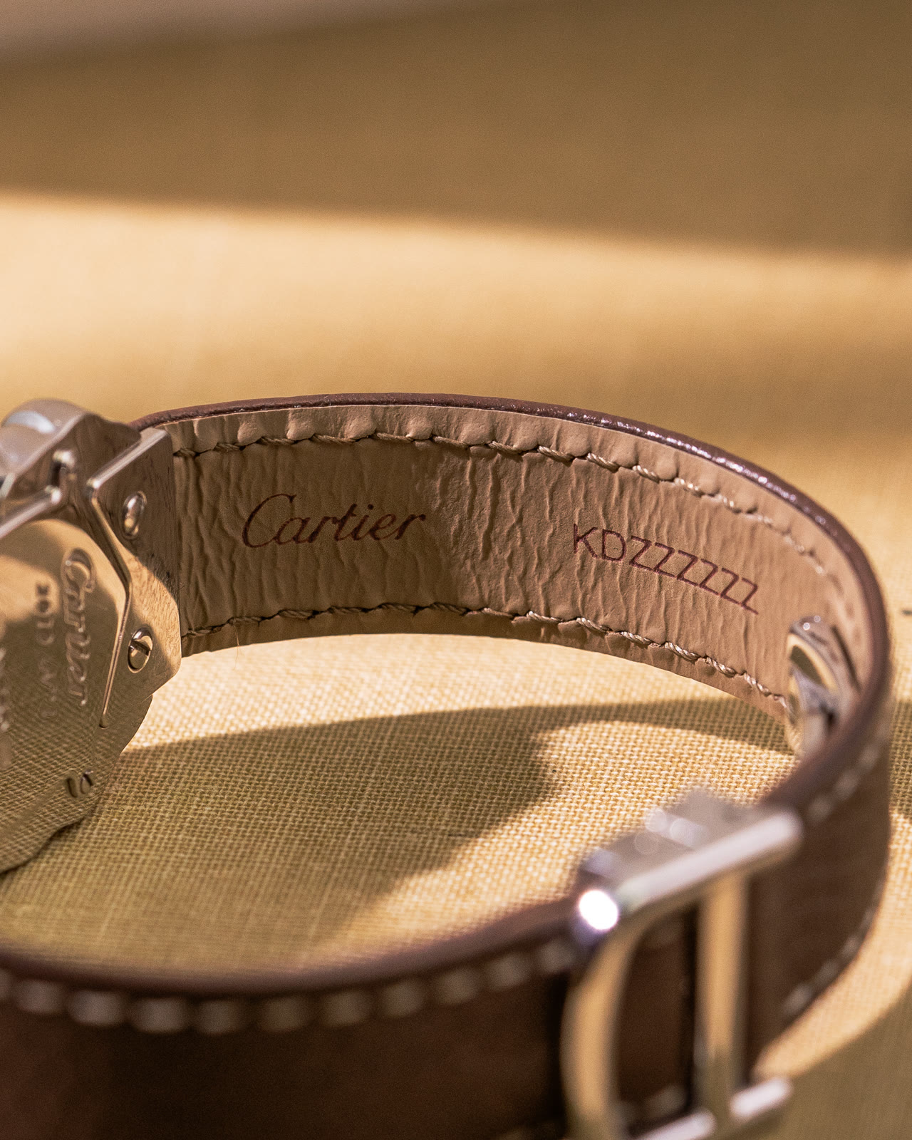 The inside of the brown Cartier strap, stamped with the Cartier name