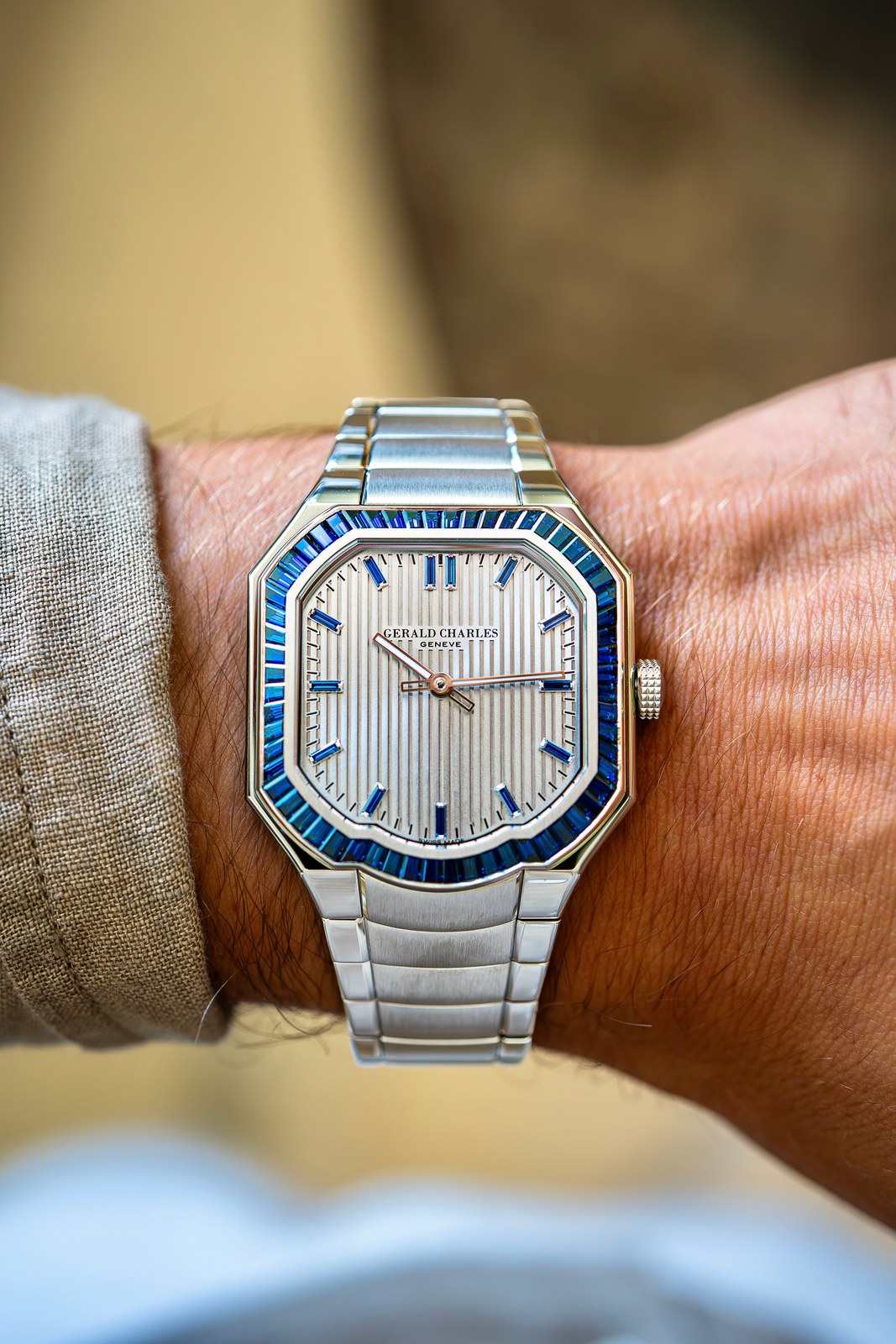 The Masterlink Gem-Set with blue sapphire bezel on a wrist, steel integrated bracelet, silver striped dial with blue stone indexes