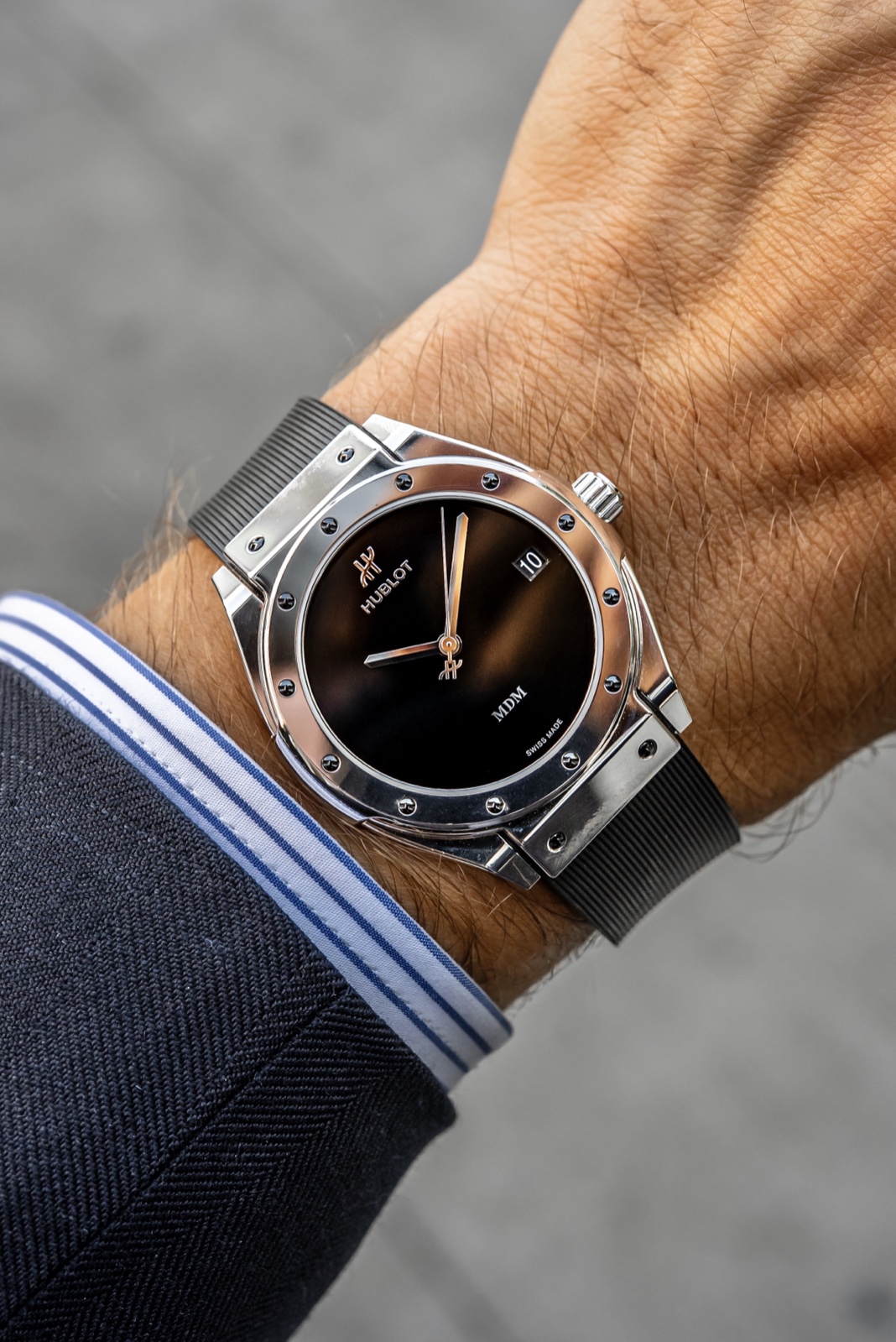 White gold Hublot Classic Fusion Tributo on a wrist, showing the black dial, MDM signature and twelve dark bezel screws