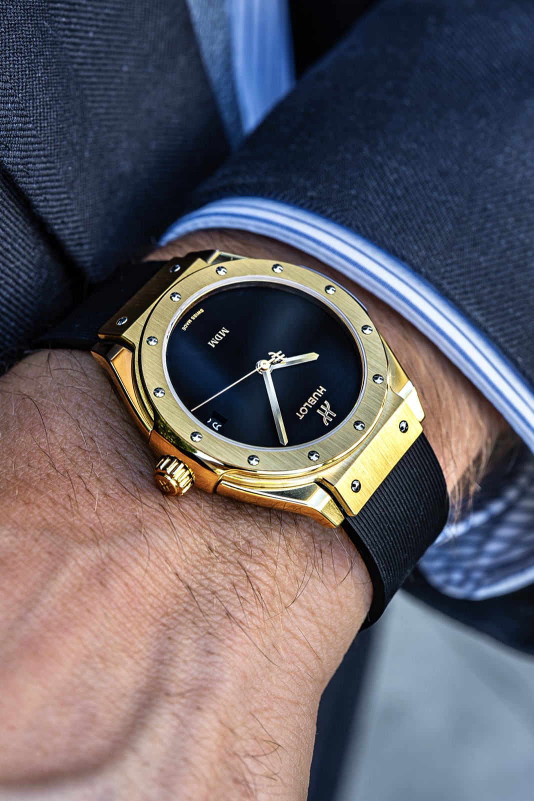 Angled view of the yellow gold Hublot Classic Fusion Tributo, with its black dial, polished case edge and black rubber strap