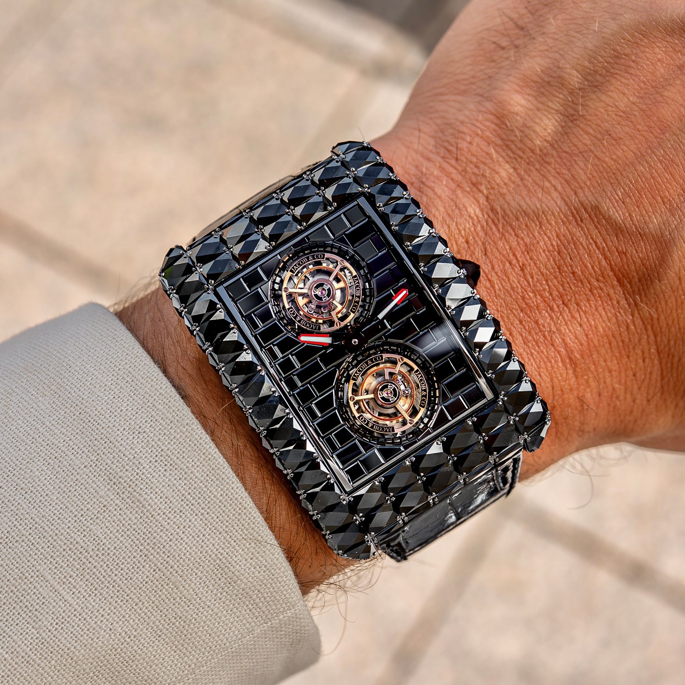 Close view of the black-treated Angel-Cut: dark stepped stones in the brick-wall pattern, the two tourbillon cages and red-tipped hands