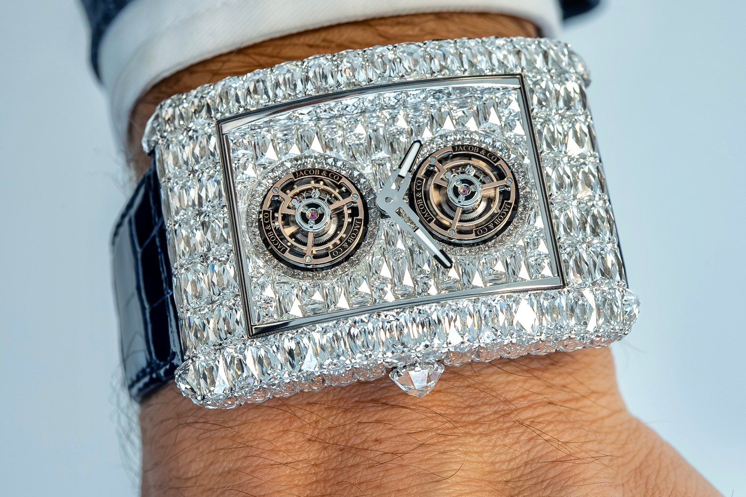 The white-diamond Angel-Cut seen from above at an angle on the wrist, showing the rectangular case outline, the diamond-set flanks and the blue alligator strap