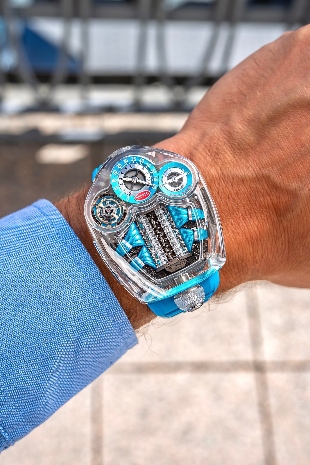 The watch under a blue shirt cuff, the transparent case catching daylight
