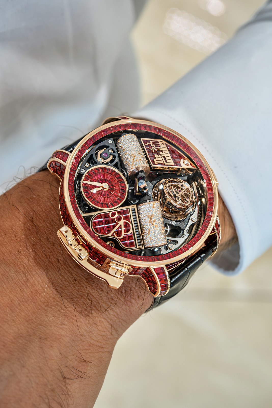 Angled wrist view of the Opera Godfather Baguette showing the two diamond-set music cylinders, red time display and exposed tourbillon