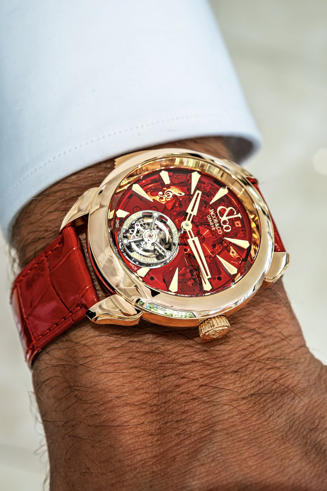 Angled view of the Palatial on a wrist, showing its polished rose-gold bezel, curved lugs, crown and red alligator strap