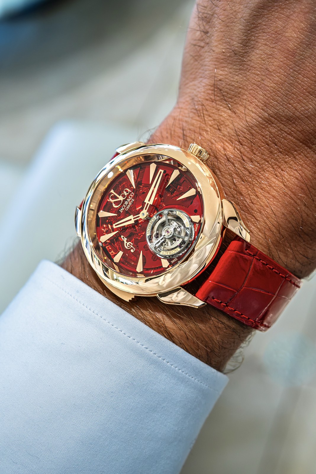 Jacob & Co. Palatial Flying Tourbillon Minute Repeater with a red dial and strap, photographed on a wrist beside a pale shirt cuff