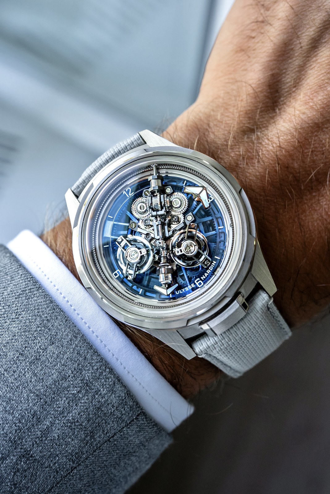Three-quarter view of the Super Freak on a wrist, showing the white-gold case, blue hour disc, grey rubber strap and two inclined tourbillons