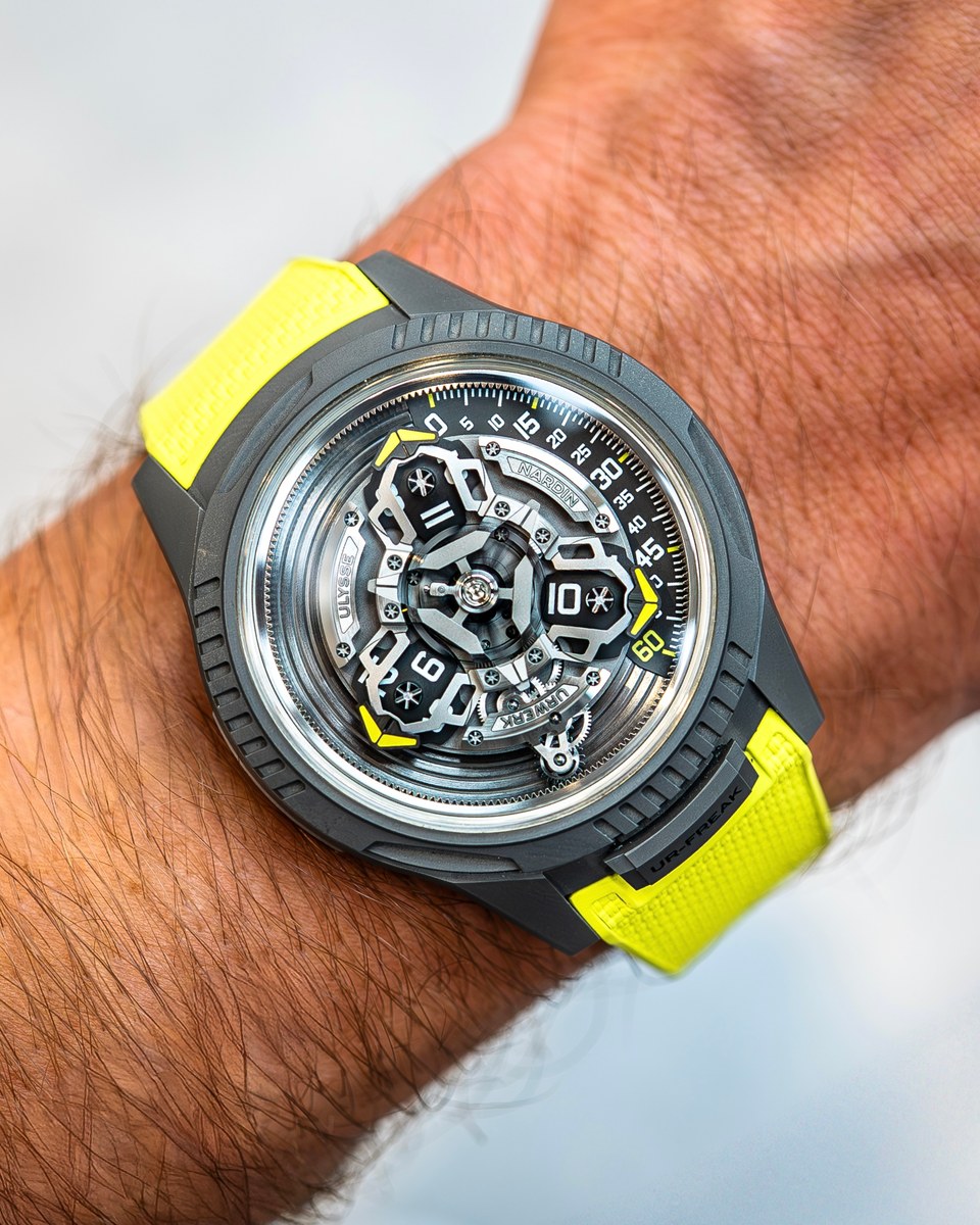 Ulysse Nardin UR-FREAK on a wrist: grey case, carousel movement turning in place of hands, yellow rubber strap