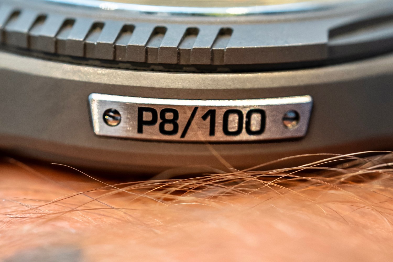 The fluted titanium case flank of the UR-FREAK with a small screwed plate reading P8/100